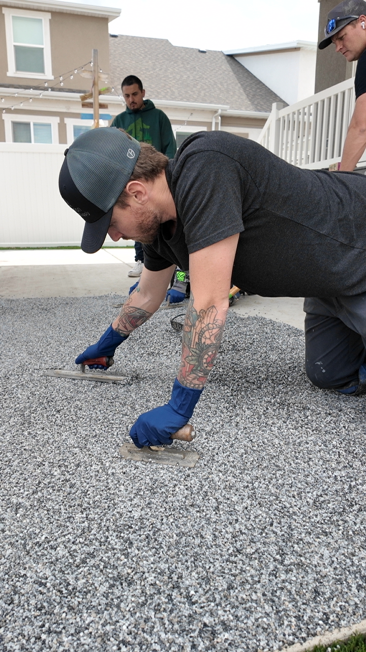 The team at Based On Concrete LLC spreads Vuba Stone on a patio in Gillette Utah, coating the concrete.